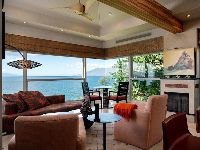 living room featuring beamed ceiling, ceiling fan, and a water and mountain view