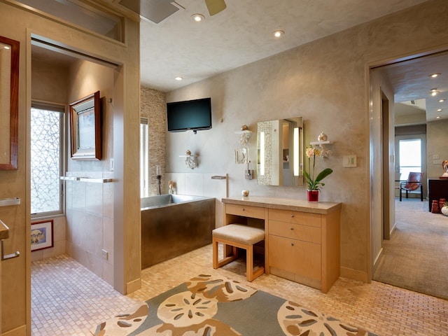 bathroom featuring vanity, tile patterned floors, and a tub