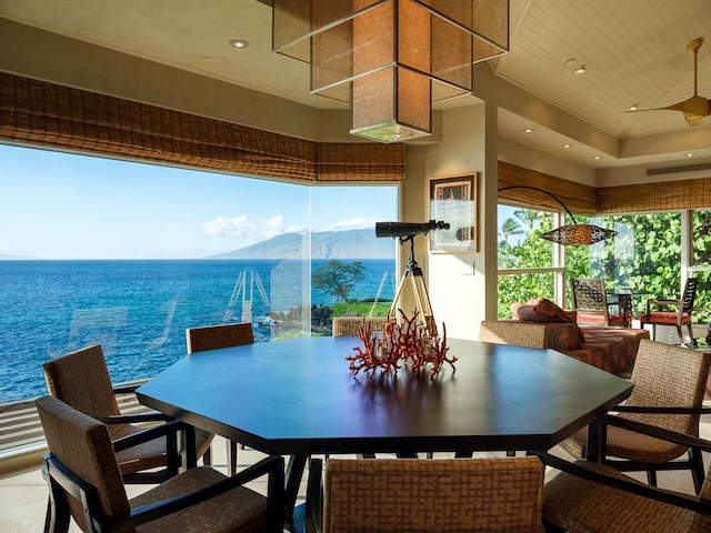 dining area featuring a high ceiling and a water and mountain view