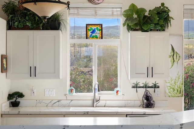 140 Kahana Ridge Dr, Lahaina, HI 96761 - kitchen featuring white cabinets, healthy amount of natural light, and light stone counters