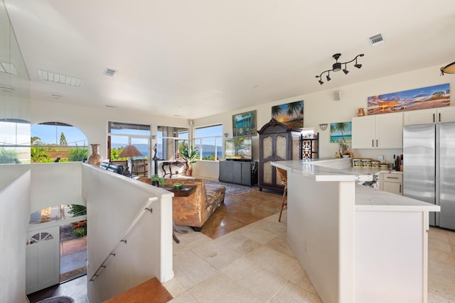 140 Kahana Ridge Dr, Lahaina, HI 96761 - kitchen featuring freestanding refrigerator, white cabinetry, open floor plan, and light stone countertops