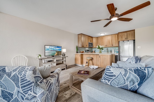 living room with light hardwood / wood-style floors and ceiling fan