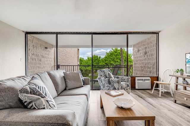 living room featuring hardwood / wood-style floors, a wall unit AC, and expansive windows