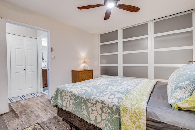 bedroom with a closet, hardwood / wood-style floors, and ceiling fan