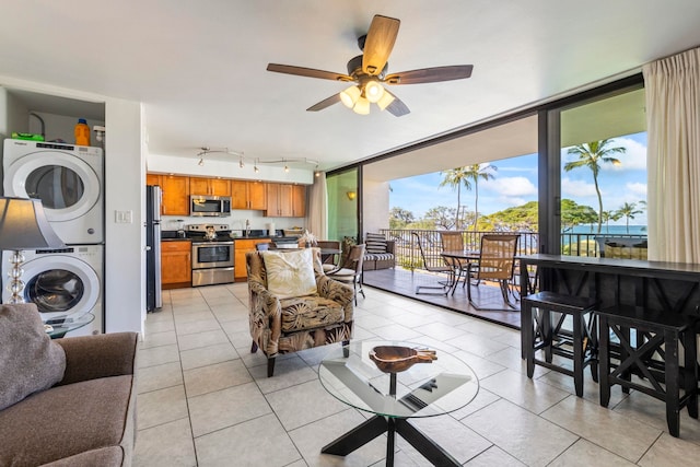 2653 S Kihei Rd Unit 306, Kihei, HI 96753 - living room with stacked washer / dryer, ceiling fan, light tile patterned floors, floor to ceiling windows, and rail lighting