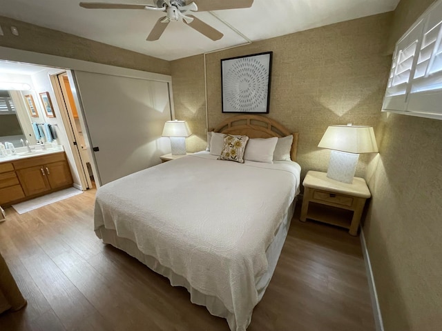 bedroom with ensuite bath, light hardwood / wood-style floors, and ceiling fan