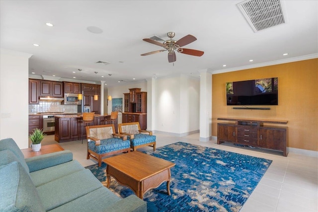 tiled living room with ceiling fan and ornamental molding