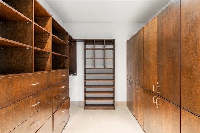 walk in closet with light tile patterned floors