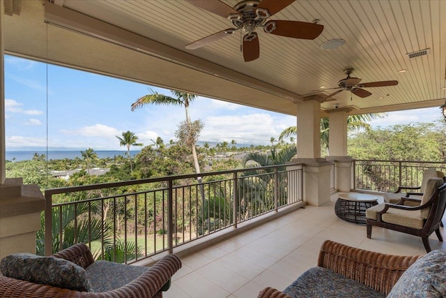 balcony featuring ceiling fan and a water view