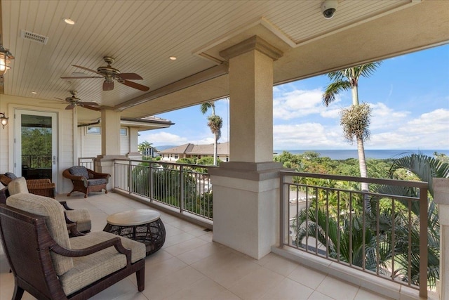 balcony with visible vents, a water view, and ceiling fan