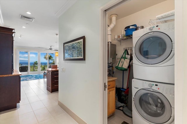 clothes washing area with ceiling fan, light tile patterned floors, and stacked washer and dryer