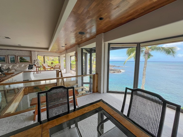 sunroom / solarium featuring a water view and wooden ceiling