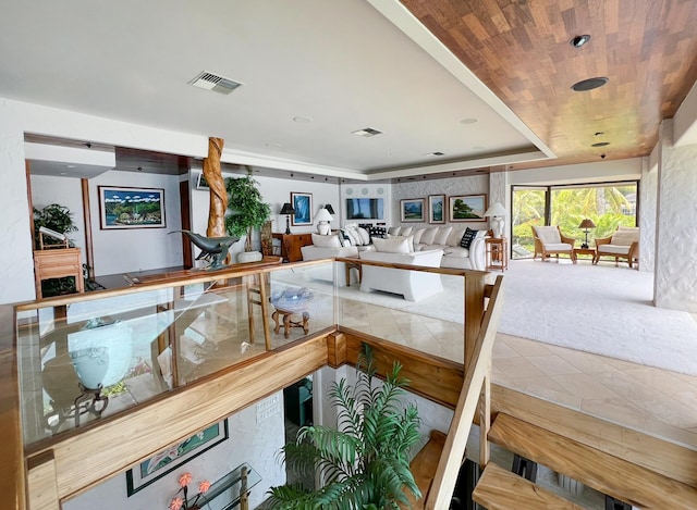 interior space with wooden ceiling, a tray ceiling, and carpet flooring