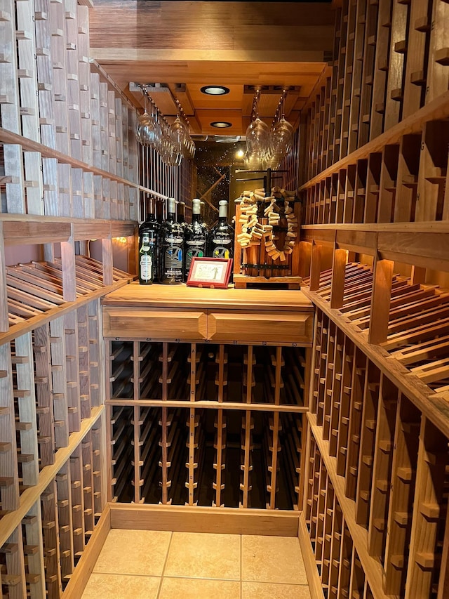 wine room with wood ceiling and tile patterned floors