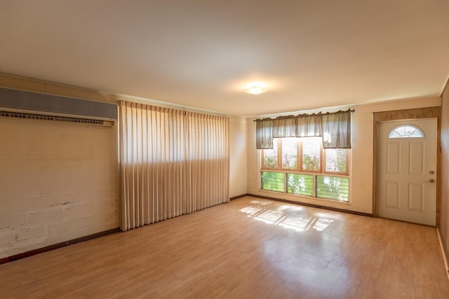 interior space featuring light hardwood / wood-style flooring, plenty of natural light, and a wall mounted air conditioner