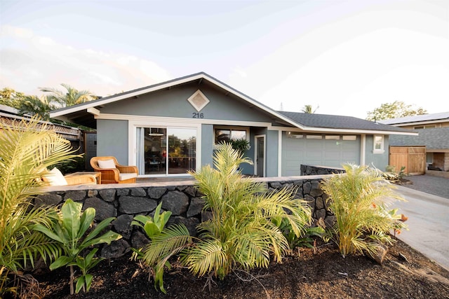 ranch-style home featuring an attached garage, fence, and stucco siding