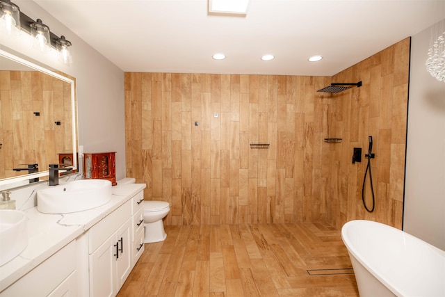 full bathroom featuring double vanity, recessed lighting, a freestanding bath, a sink, and a tile shower