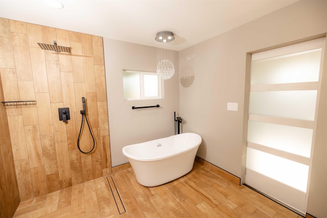 full bath with tiled shower, a freestanding bath, and wood finished floors