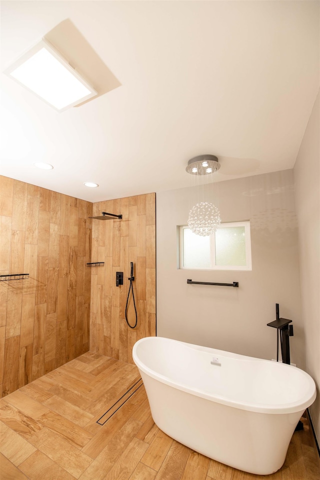 full bathroom featuring a soaking tub, tiled shower, and wood finished floors