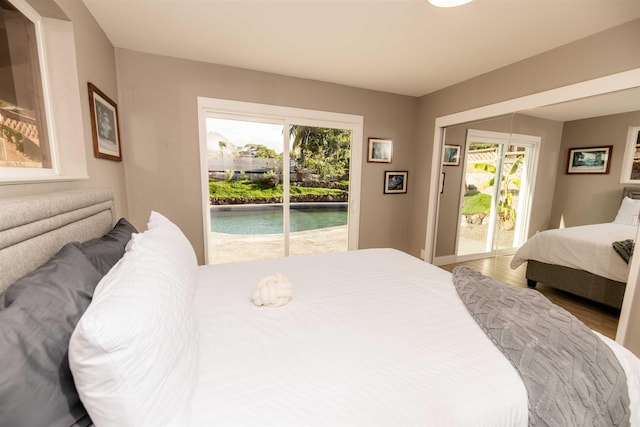 bedroom featuring multiple windows, wood finished floors, and access to exterior