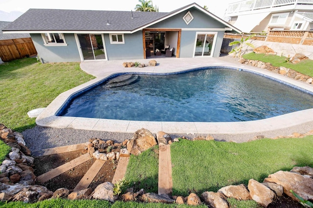 view of swimming pool featuring a patio, a yard, and a fenced backyard