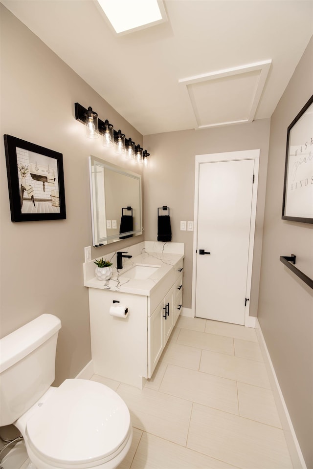 bathroom featuring baseboards, vanity, toilet, and tile patterned floors