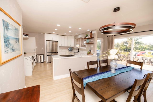 dining area with light wood-type flooring and recessed lighting