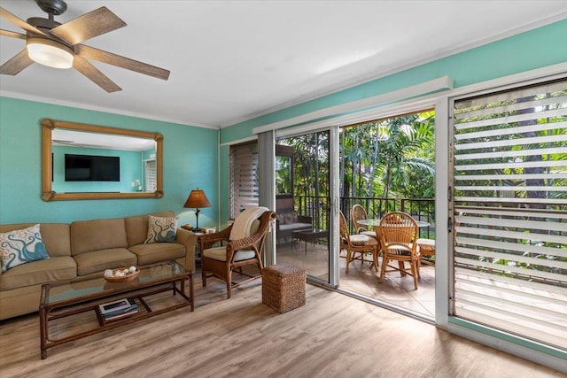 living room featuring ceiling fan, ornamental molding, and light hardwood / wood-style flooring