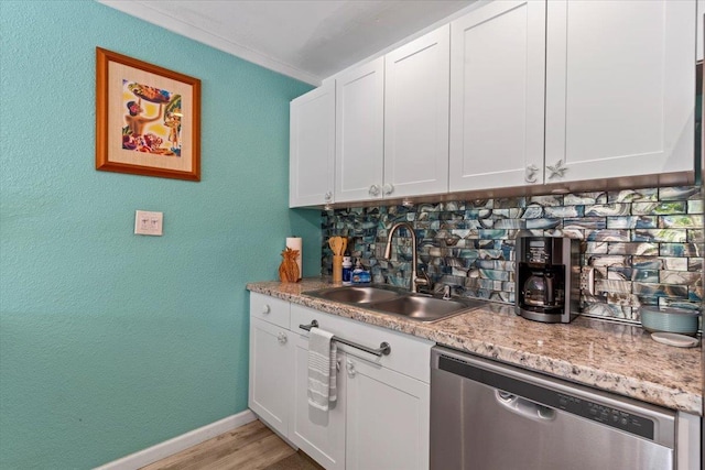 kitchen featuring white cabinets, dishwasher, decorative backsplash, sink, and light wood-type flooring