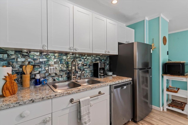 kitchen featuring backsplash, sink, white cabinetry, and appliances with stainless steel finishes