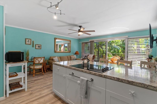 kitchen featuring ceiling fan, black electric cooktop, light wood-type flooring, light stone countertops, and white cabinets