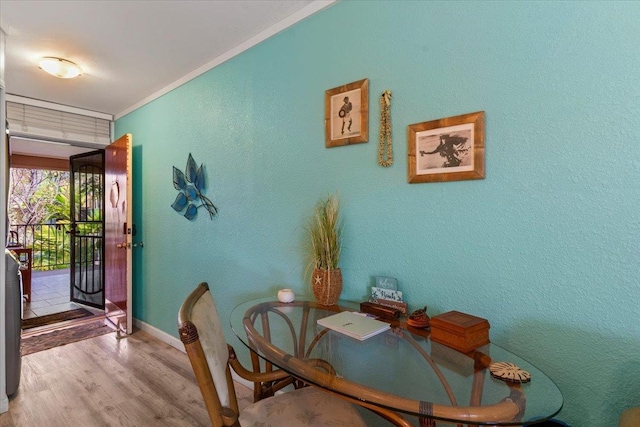 dining room with ornamental molding and light wood-type flooring