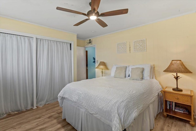 bedroom featuring ceiling fan, light wood-type flooring, and ornamental molding