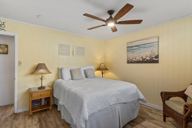 bedroom with ceiling fan, ornamental molding, and hardwood / wood-style floors