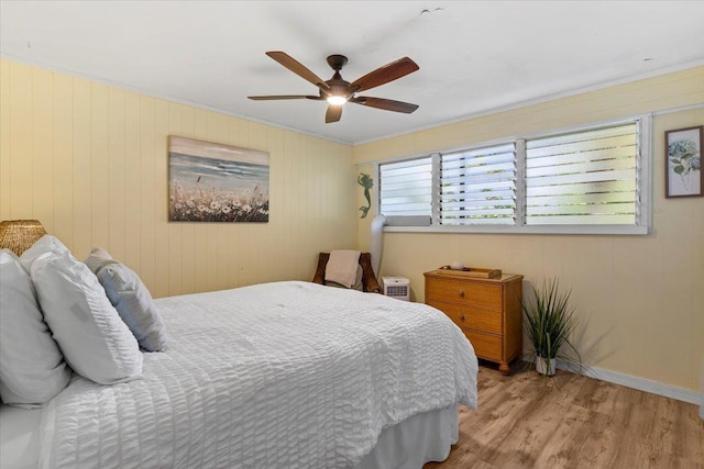 bedroom featuring ceiling fan, light hardwood / wood-style floors, and ornamental molding