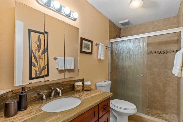 bathroom featuring toilet, an enclosed shower, and vanity