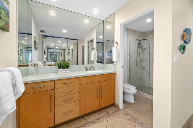 bathroom featuring vanity, tile patterned floors, a shower with door, and toilet