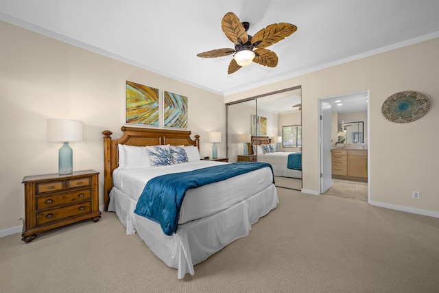 carpeted bedroom featuring ornamental molding, ceiling fan, ensuite bath, and a closet