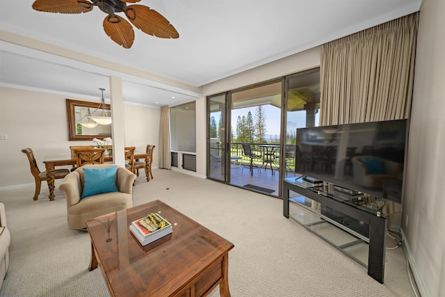 carpeted living room featuring ornamental molding and ceiling fan