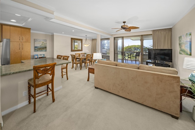 living room with crown molding, light colored carpet, and ceiling fan