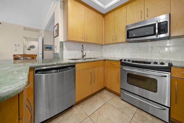 kitchen featuring tasteful backsplash, sink, light tile patterned floors, stainless steel appliances, and light stone countertops