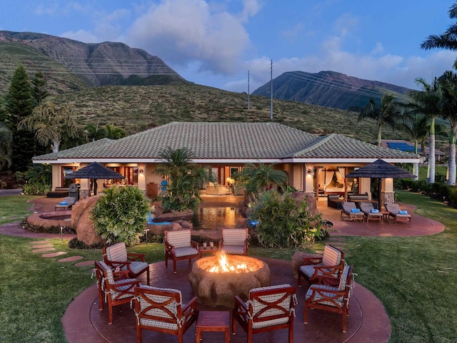 view of patio / terrace with a mountain view and an outdoor fire pit