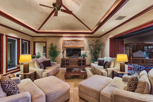 living room featuring crown molding, a raised ceiling, and ceiling fan