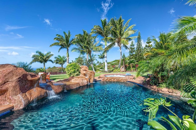 view of pool with an in ground hot tub and pool water feature