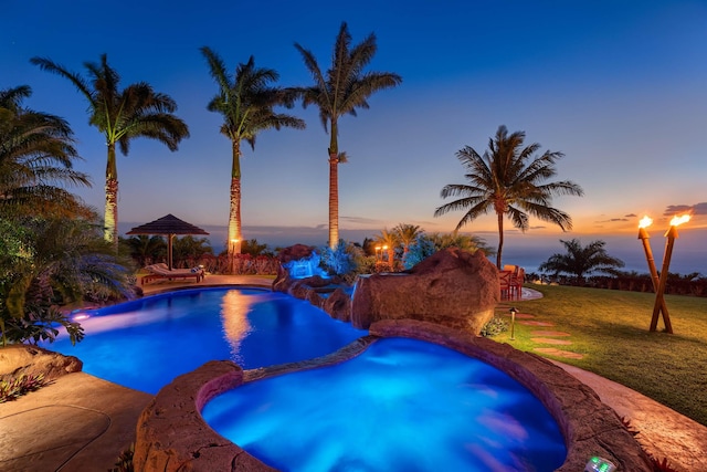 pool at dusk featuring a gazebo and a yard