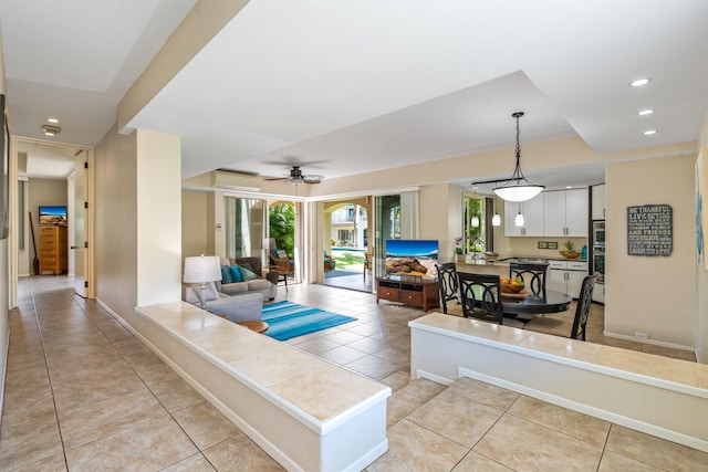 tiled living room with a healthy amount of sunlight and ceiling fan