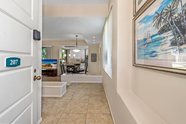 hall with plenty of natural light and light tile floors