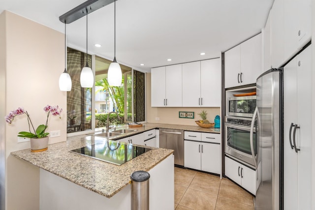 kitchen featuring sink, white cabinetry, stainless steel appliances, kitchen peninsula, and pendant lighting