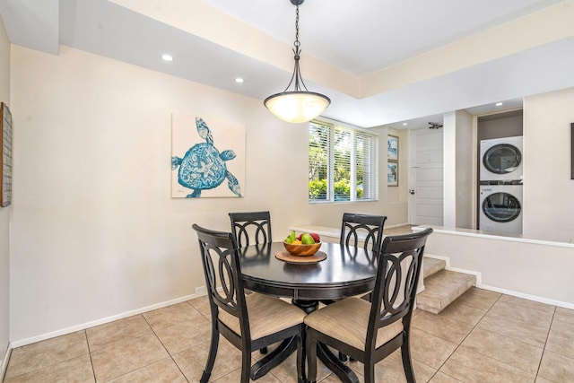 dining area with light tile floors and stacked washing maching and dryer