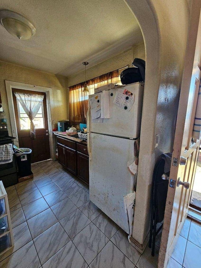 kitchen featuring white fridge and a textured ceiling